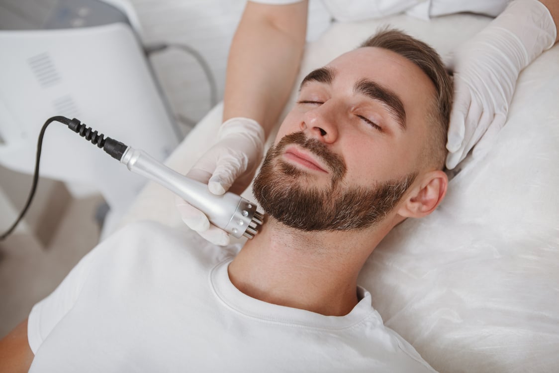 Handsome man getting facial skincare treatment at salon